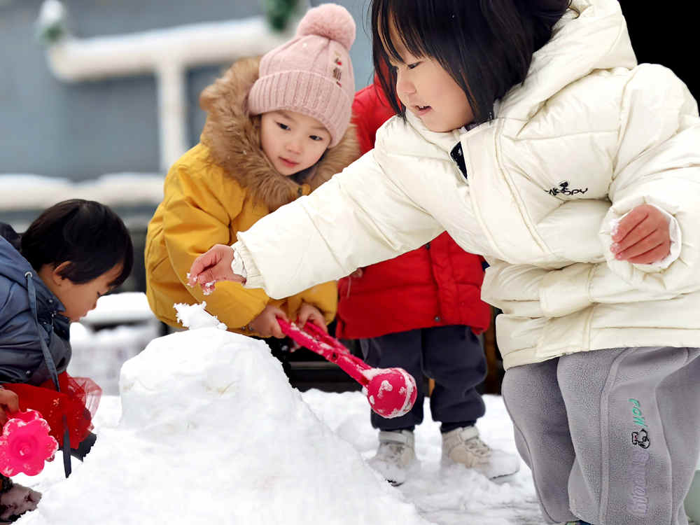 孩子們開心地堆雪人。 婁亞斐攝