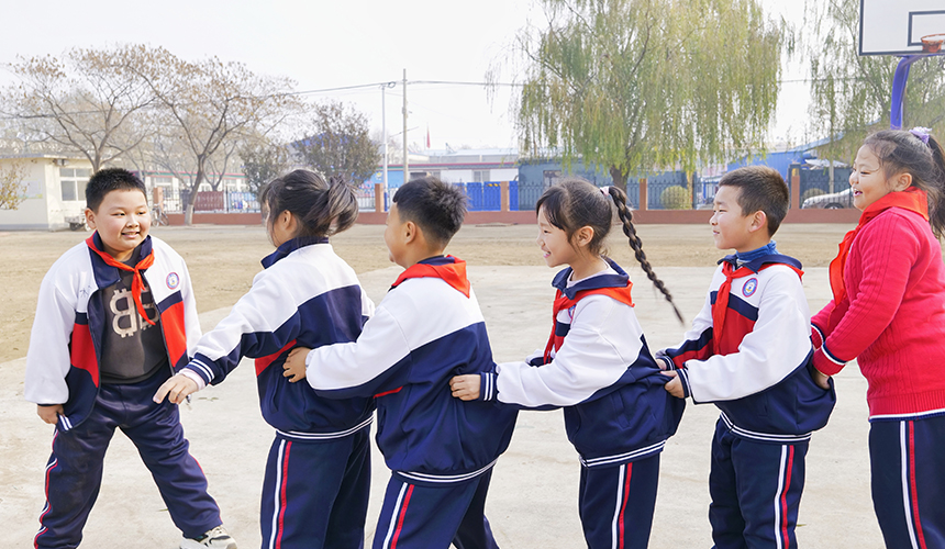 乐亭县新寨小学的孩子们玩“老鹰抓小鸡”游戏。 武迎春摄