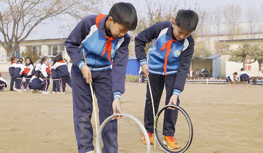 乐亭县新寨小学的孩子们在滚铁环。 武迎春摄