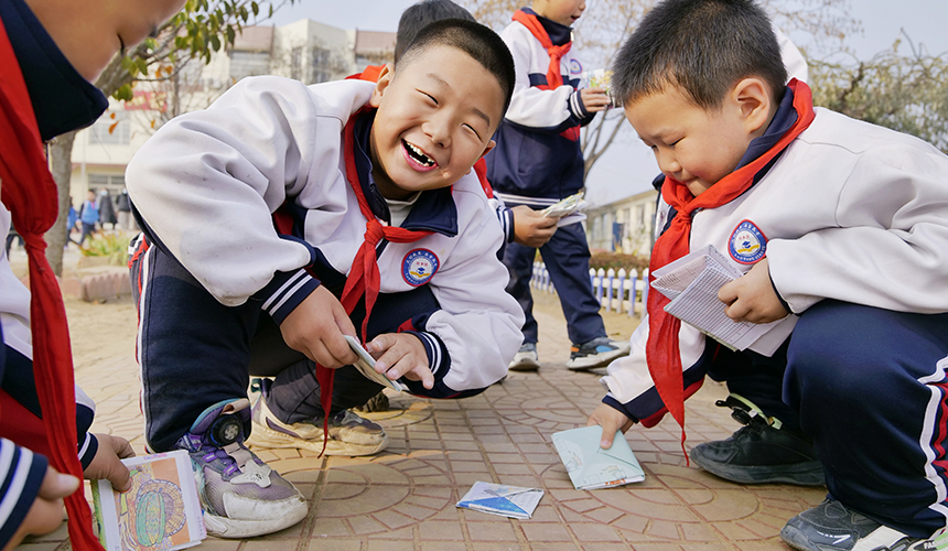乐亭县新寨小学的孩子们在扇画片。 武迎春摄