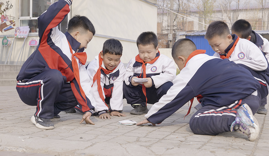 乐亭县新寨小学的孩子们在玩扇画片游戏。 武迎春摄