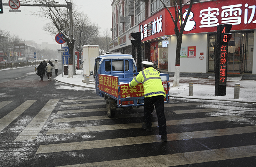 交警帮助一抛锚车辆过马路。 白天龙摄