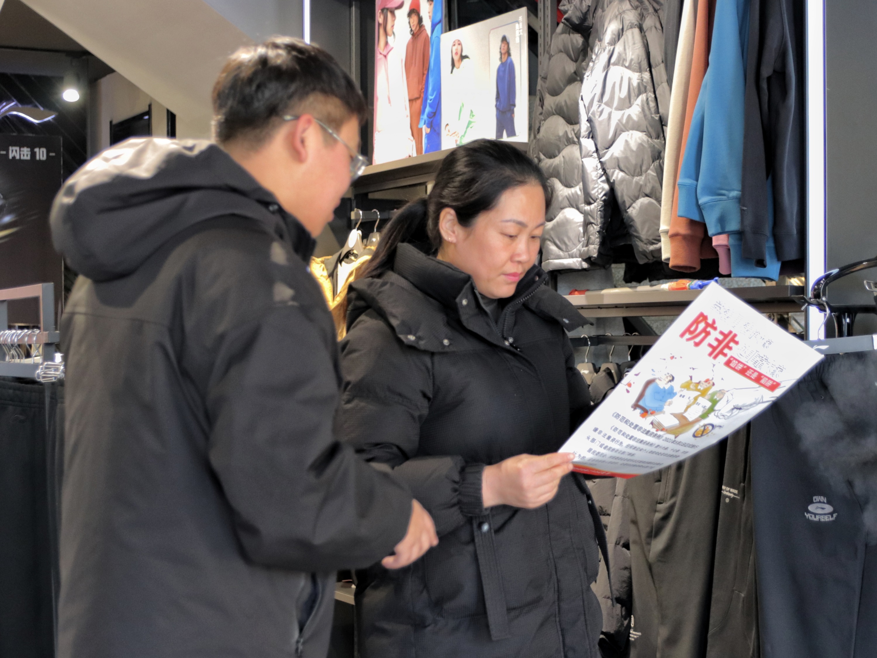 金融办工作人员入服装店进行宣传。 张光伟摄