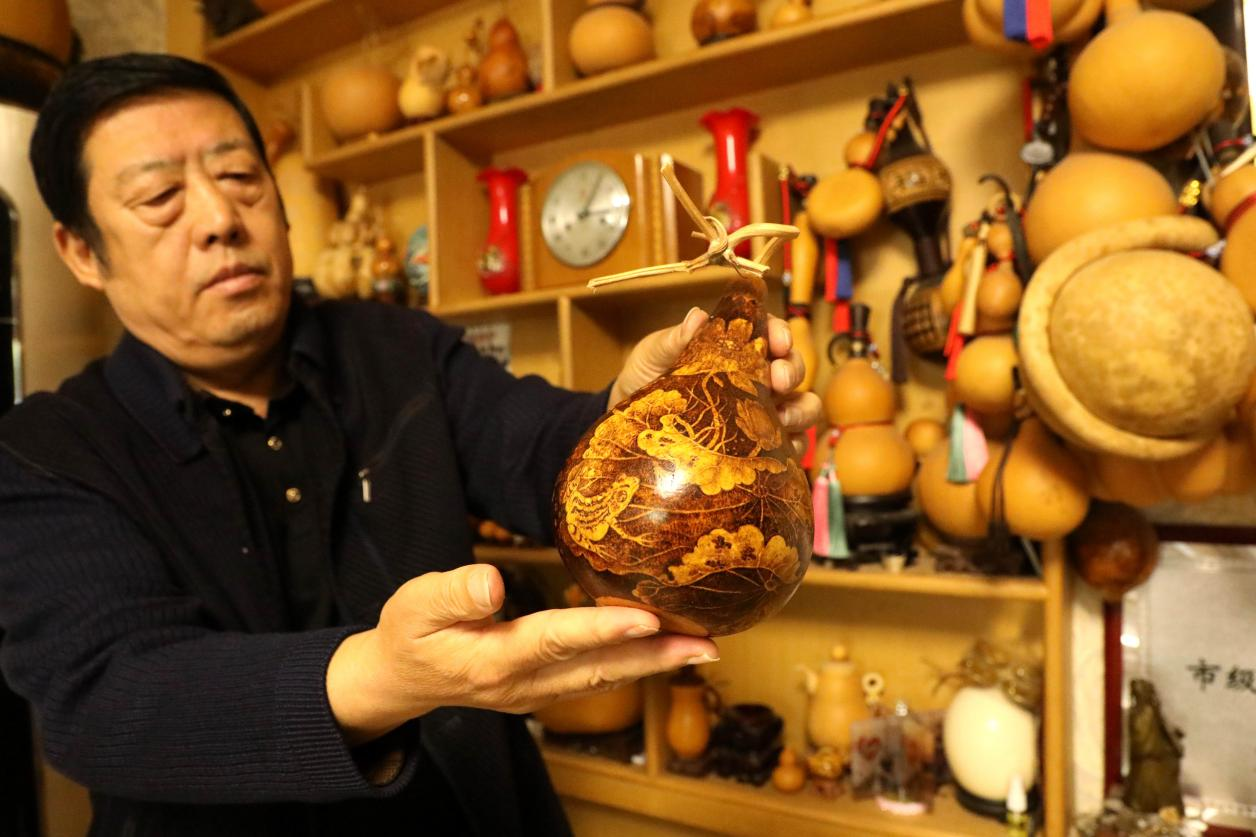 烙画艺人阮永军正在展示新作品。 陈宏儒摄