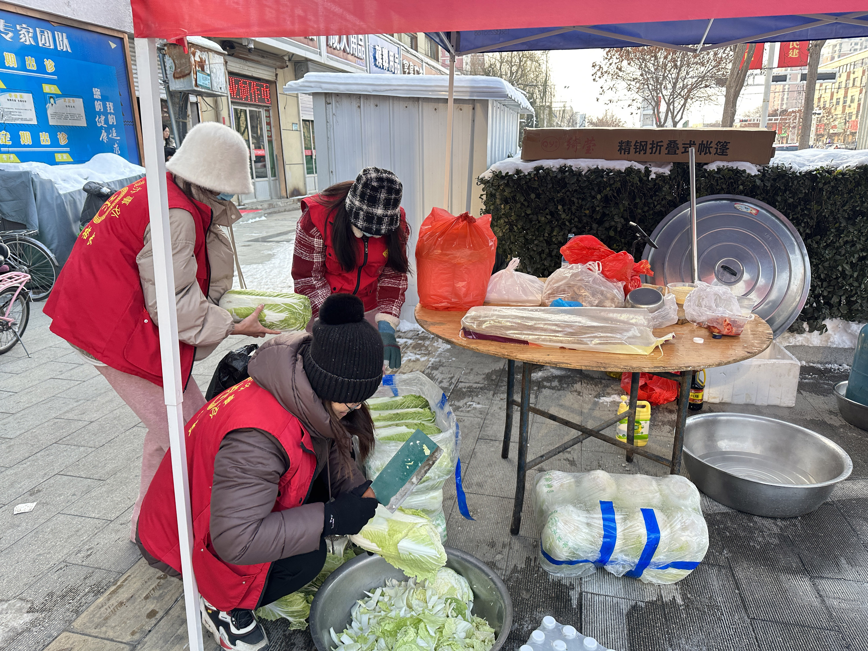 12月19日，在河北省高碑店市康太医院门前，志愿者们正在有序准备爱心午餐。 赵蕾摄