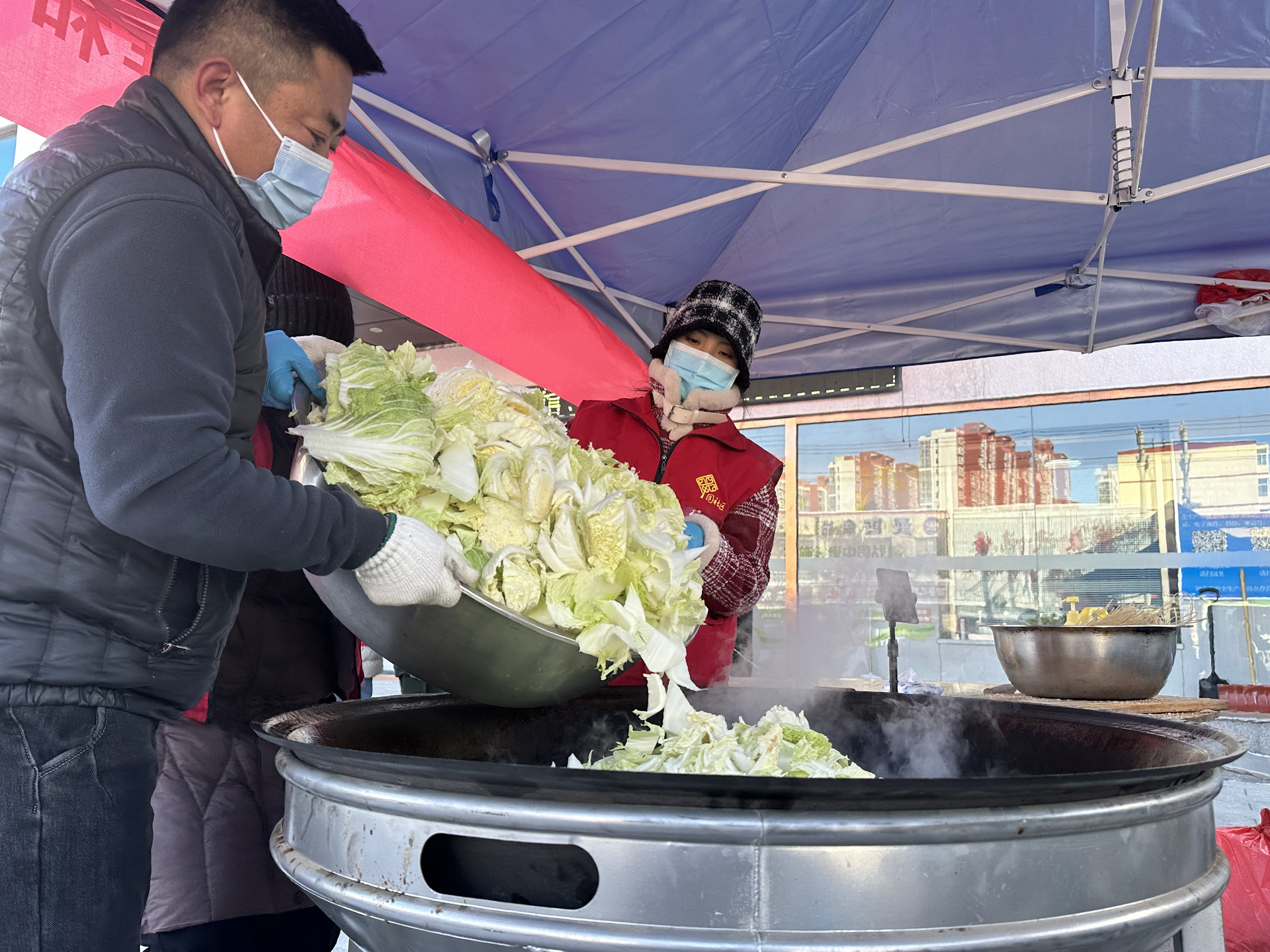 12月19日，在河北省高碑店市康太医院门前，志愿者们正在制作爱心午餐。 赵蕾摄