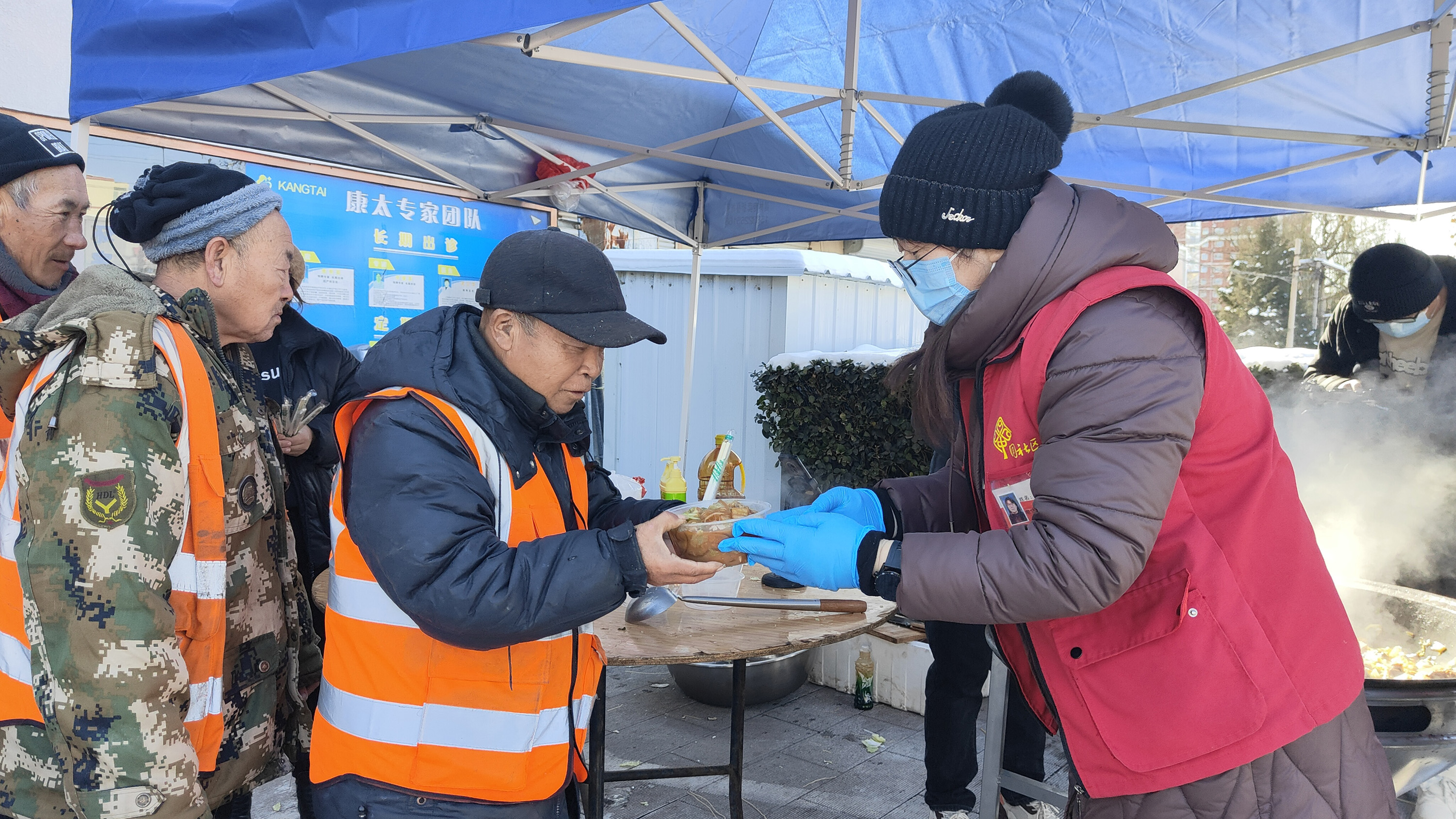 12月19日，在河北省高碑店市康太醫院門前，志願者們正在為前來就餐的環衛工人盛菜。 趙蕾攝