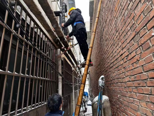 熱力公司維修人員在冒雪修供暖管道。 王麗攝
