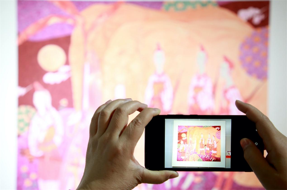 一名观众正在用手机记录精彩。 殷实摄