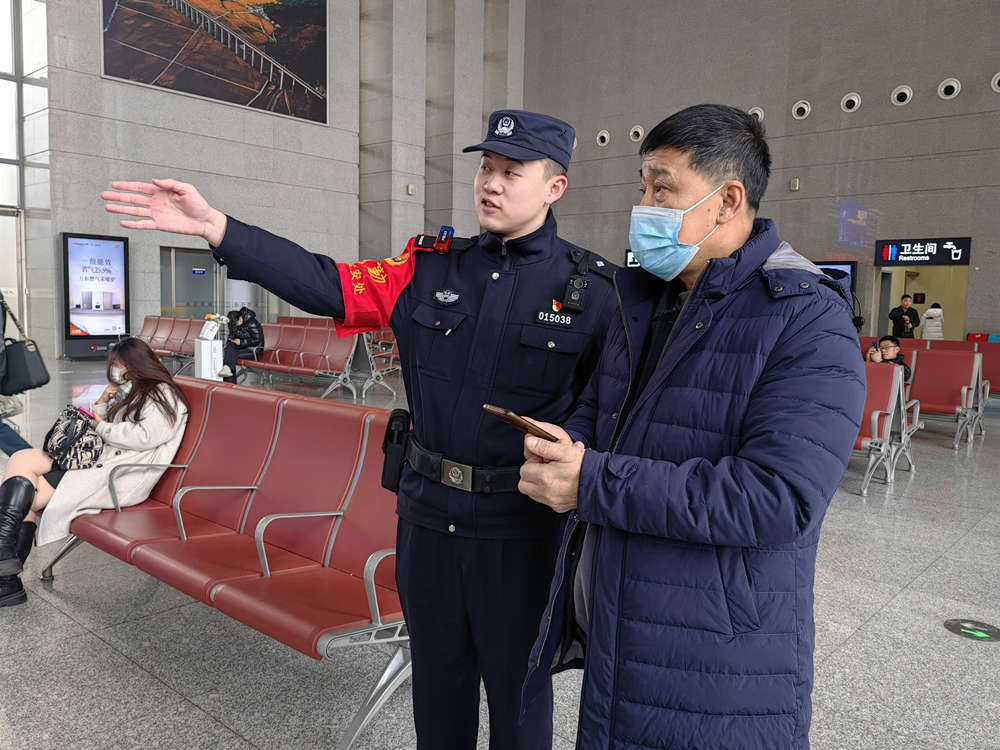 1月9日，在京廣高鐵高碑店東站候車大廳，執勤民警指引旅客乘車。 王娟攝