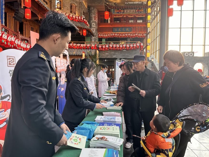 工作人员向市民发放食品安全宣传品。 齐东青摄