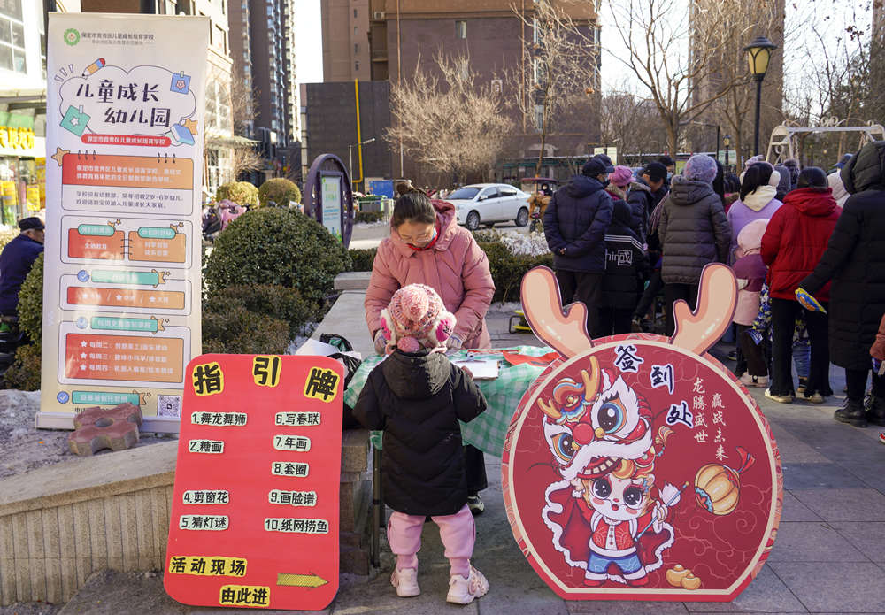 幼儿园老师为参与活动的社区儿童签到。 耿培轩摄