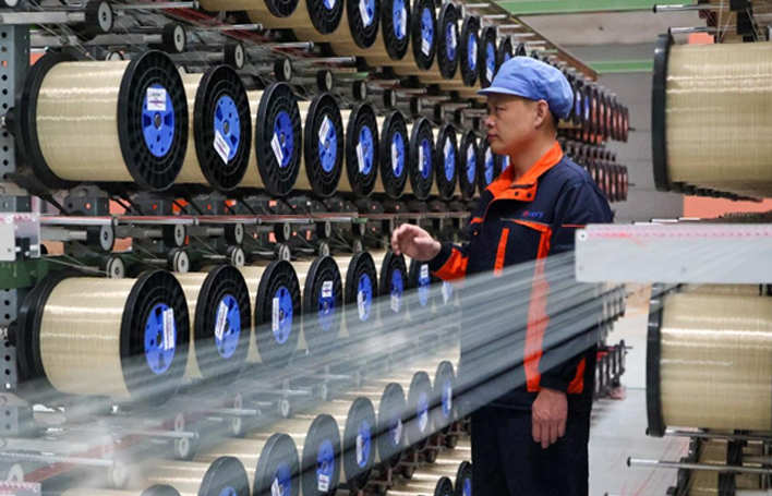 工人检查网丝整经工序中是否有断丝、绕丝的情况