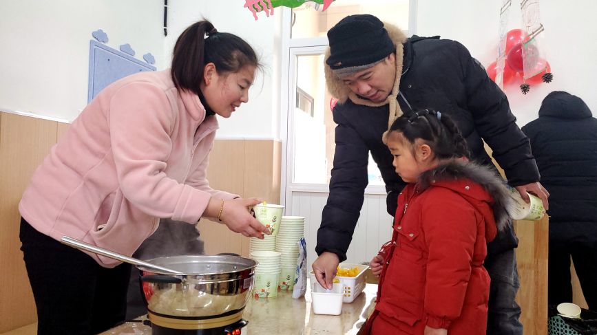 家長帶孩子在小吃街裡品味年味兒。馬靜攝