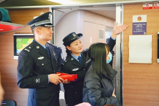 石家庄鐵路公安處乘警支隊民警向旅客介紹列車報警標識。賈義涵攝