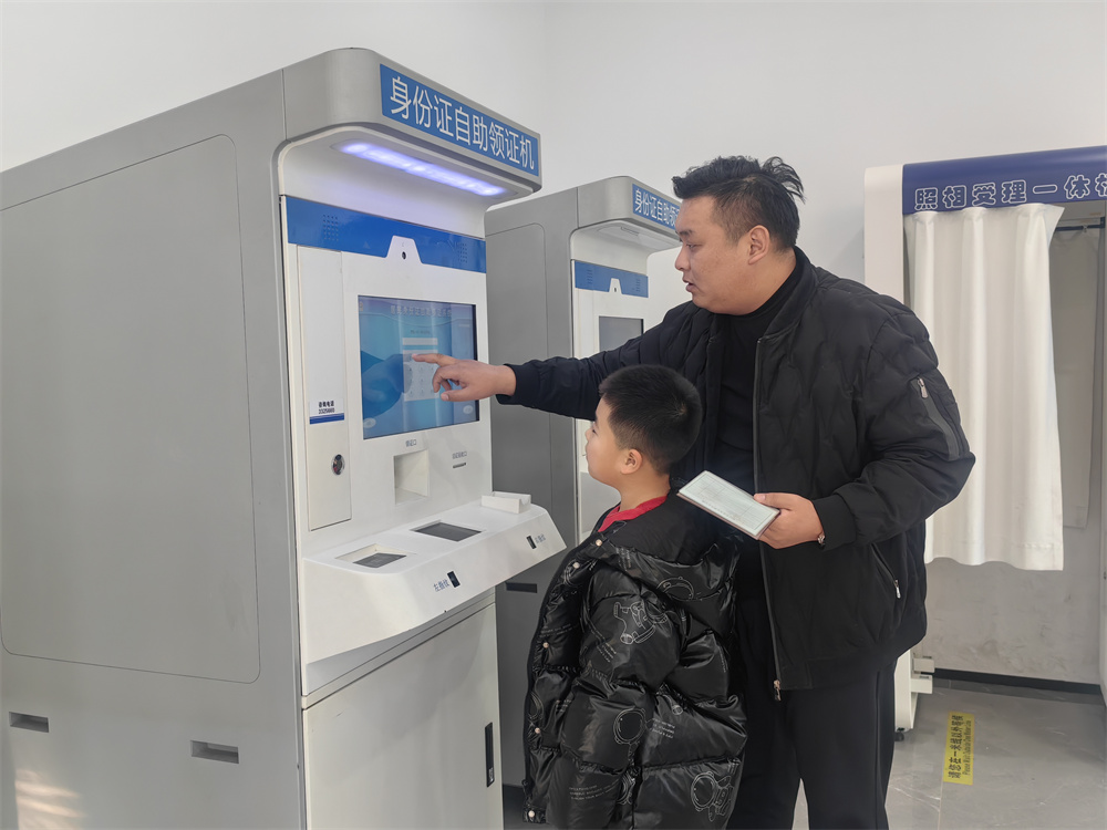 1月25日,三河市燕郊綜合服務大廳,市民通過身份証自助取証機領取身份証。張曉娜攝