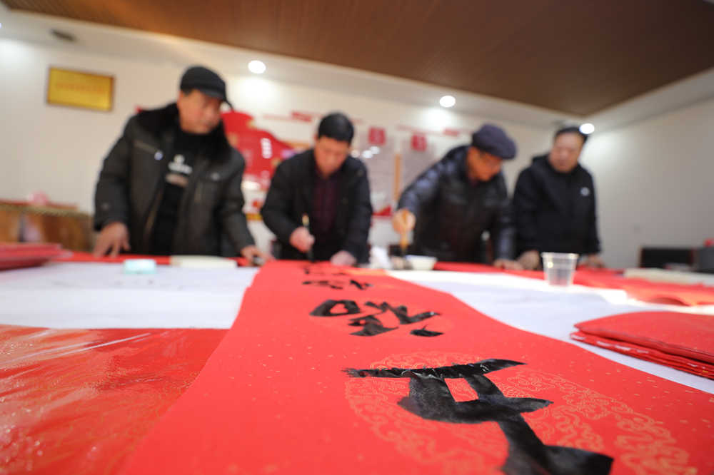 农民书法家书写春联。田博摄