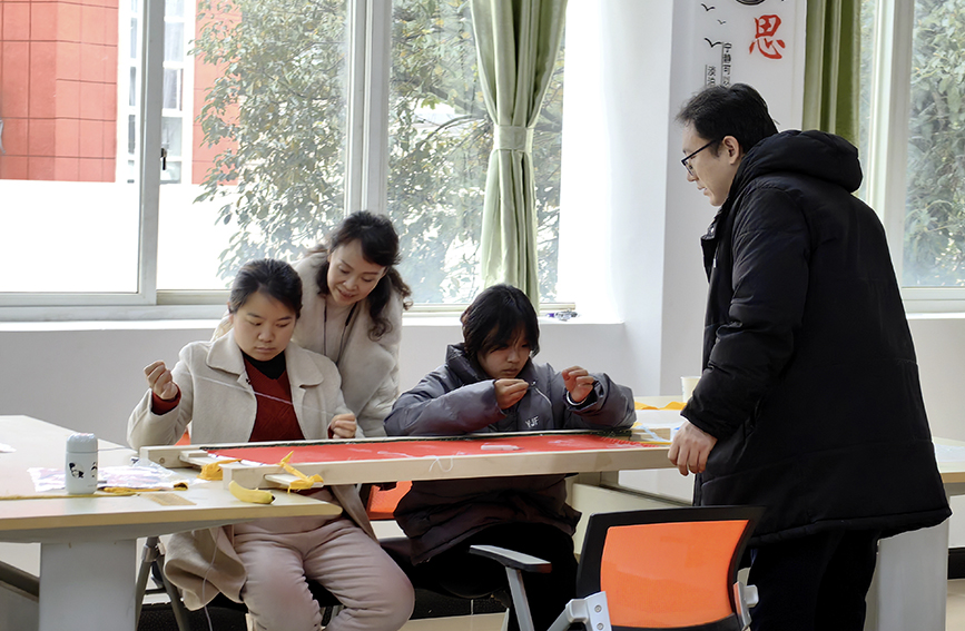 学院师生近距离接触和学习非遗京绣技艺。苏培摄