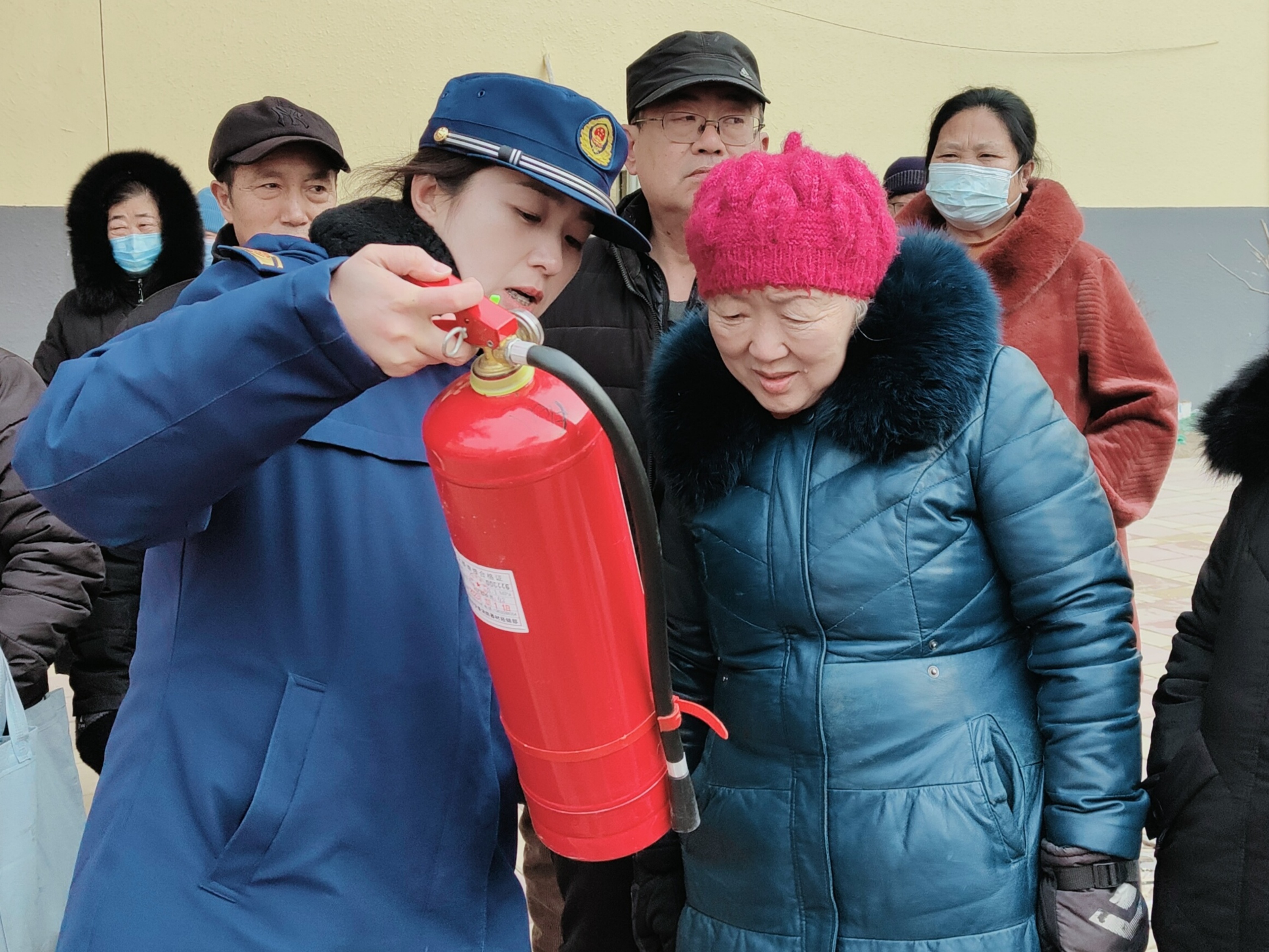 消防宣传员正在为居民讲解消防器材的使用方法。侯霁航摄