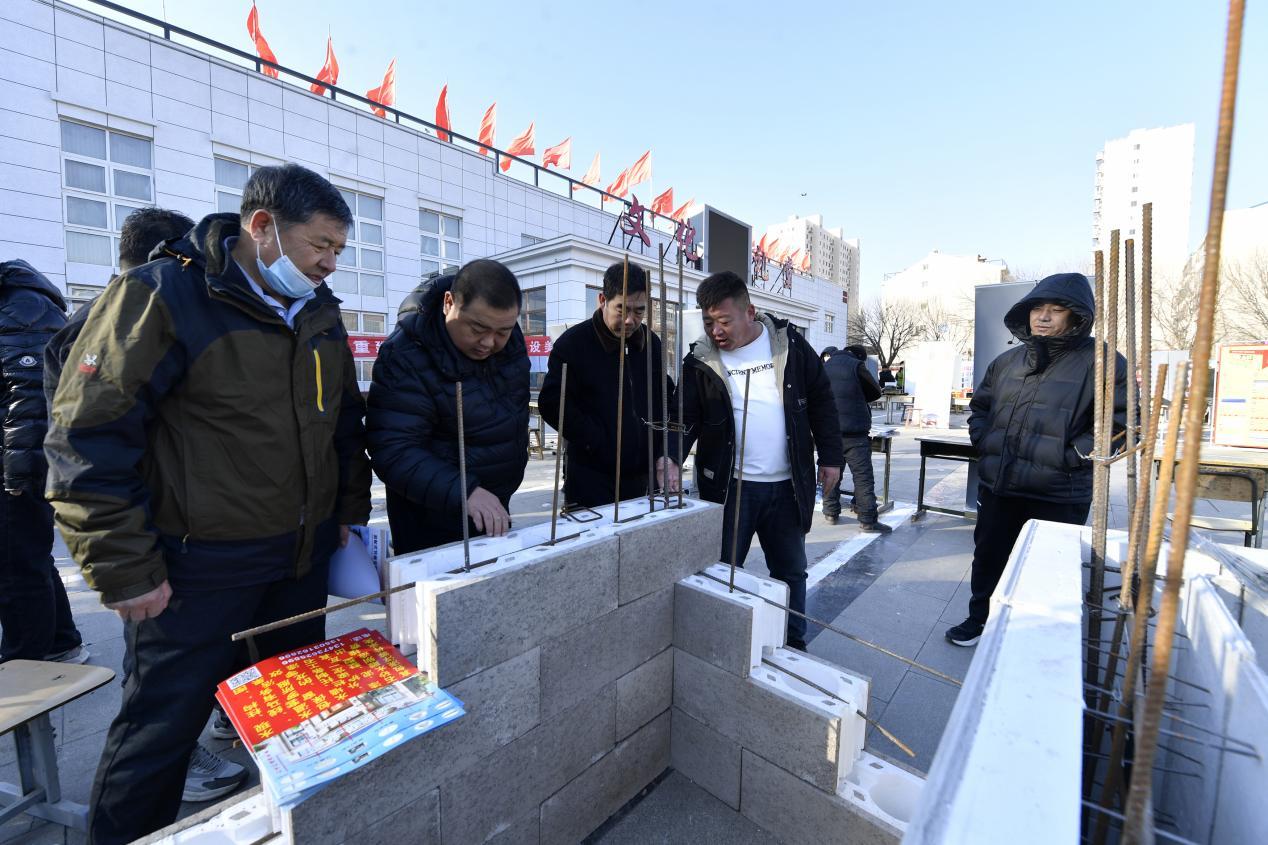 在文安县新镇镇芦阜庄村“建材大集”活动现场，当地建筑企业工作人员（右二）正在向村民介绍建筑材料。王晖摄