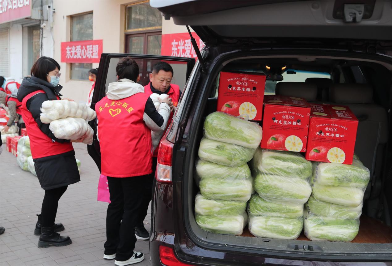 志愿者将慰问品装车准备出发。陈英华摄