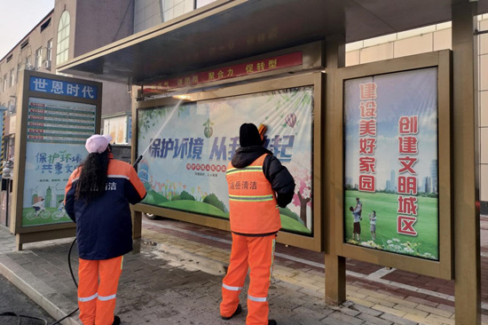 2月5日，徐水区环卫工人在清洗路边候车亭。袁达摄