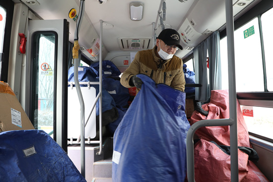 公交司機正在將發往徐水區東釜山鄉的快件裝車。白天龍攝