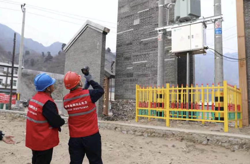 2月5日，国网涞水县供电公司员工孙宇、李阳对刘家河村变压器进行巡视和测温。张宏伟摄