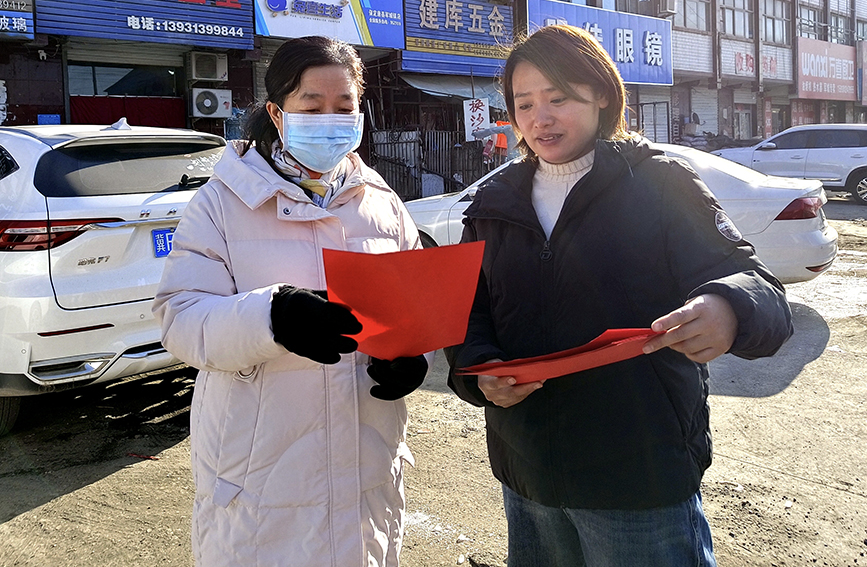 志愿者发放移风易俗明白纸。李蕾摄