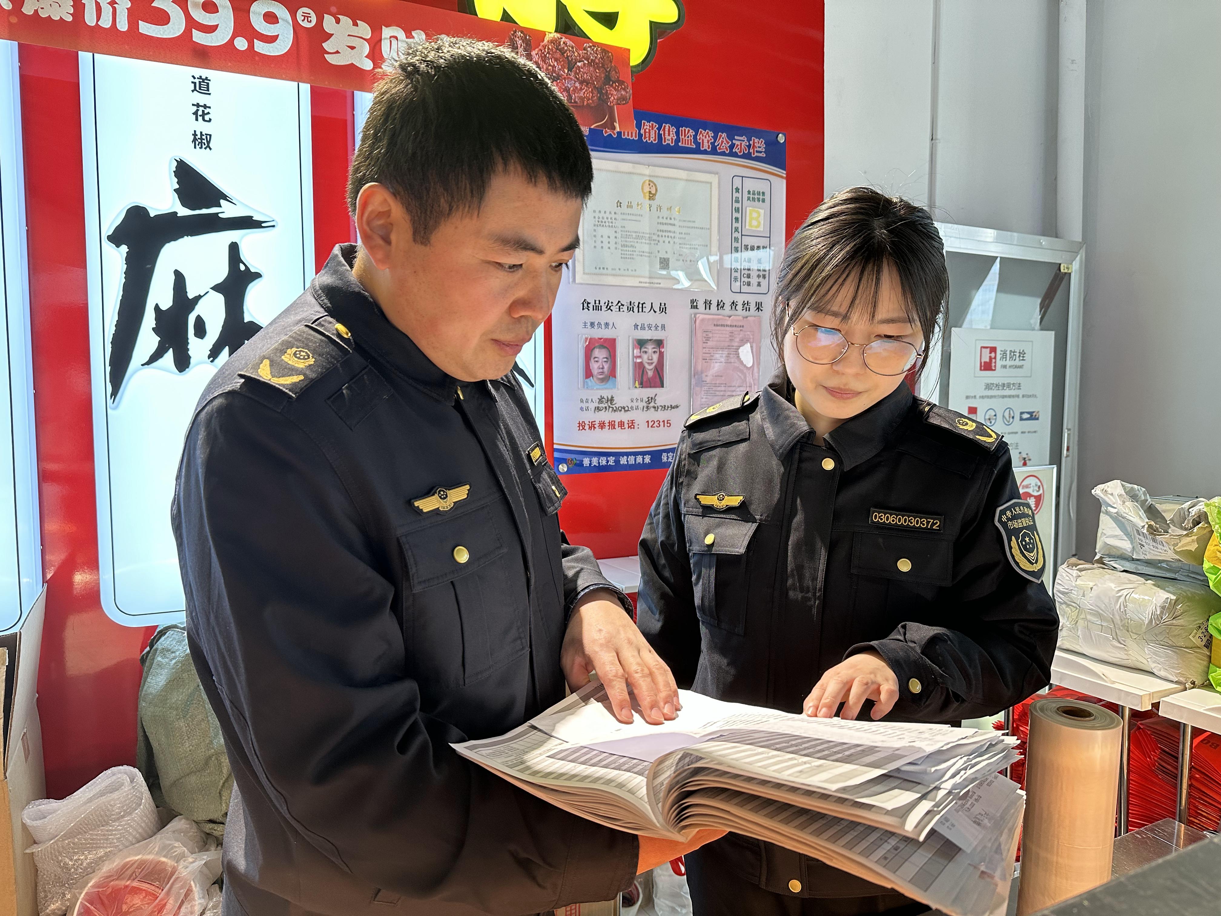 执法人员检查餐饮单位台账。齐东青摄