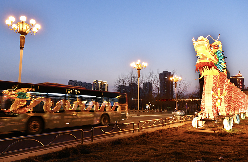 在沧州市新华中路，装饰巨龙映在路过的公交车身上。苑立伟摄
