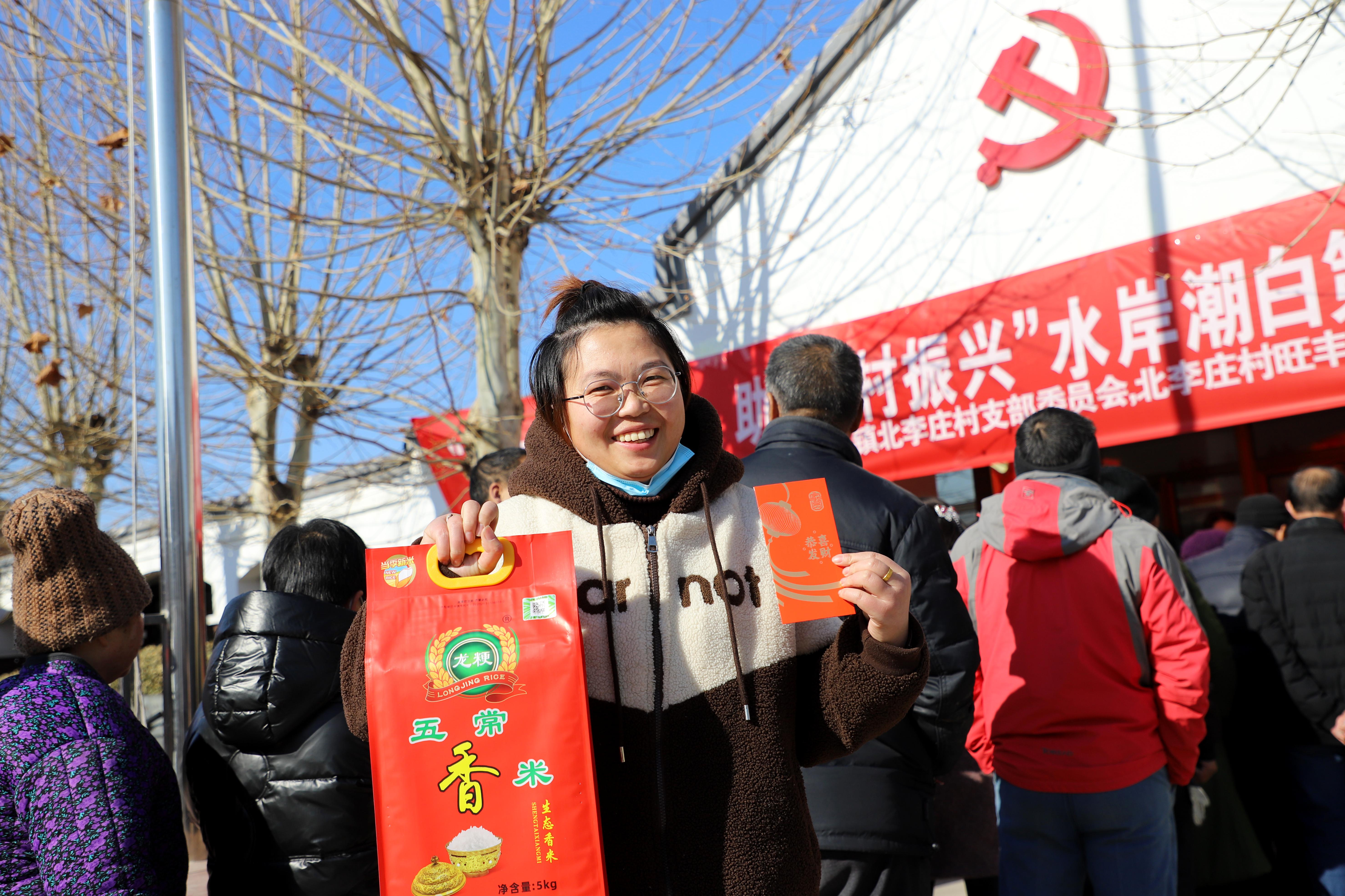 村民展示領取到的分紅和大米。朱鈺爽攝
