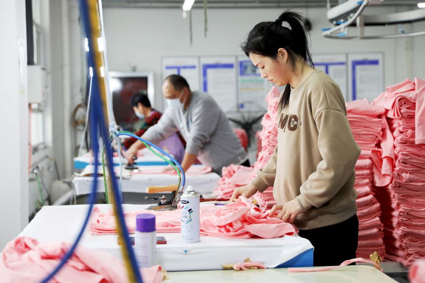 2月19日，在肃宁县一家服装加工企业，工人正在熨烫文化衫成衣。刘巨雷摄