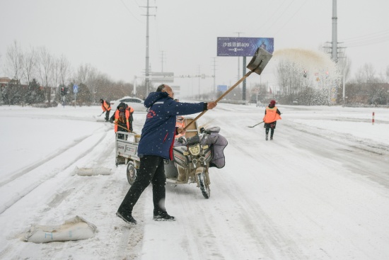 在沙河市鋼鐵路段 道路養護人員正在撒鹽。高儒森攝