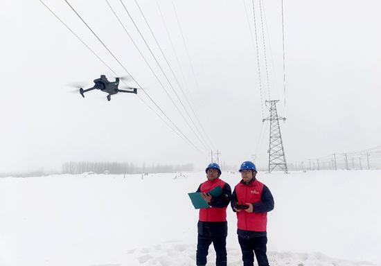 国网石家庄市鹿泉区供电公司工作人员使用无人机对110千伏鹿李线进行覆冰覆雪情况巡检。张静摄