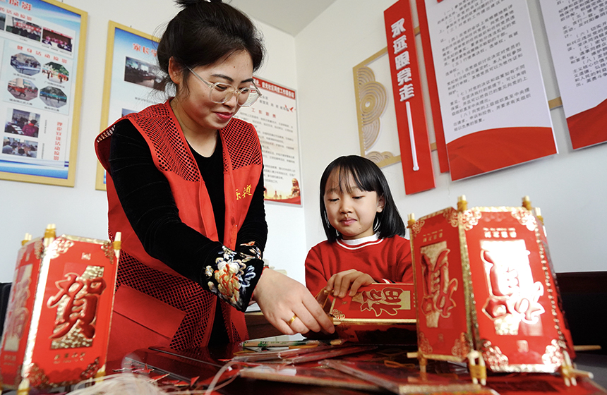 活动现场，工作人员和孩子一起制作灯笼。侯亚婷摄
