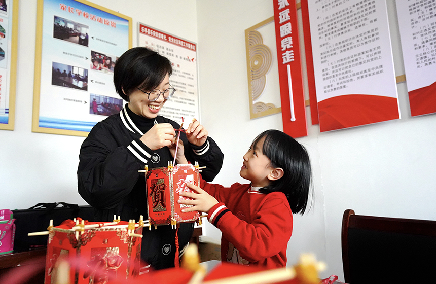 活动现场，工作人员和孩子一起制作灯笼。侯亚婷摄