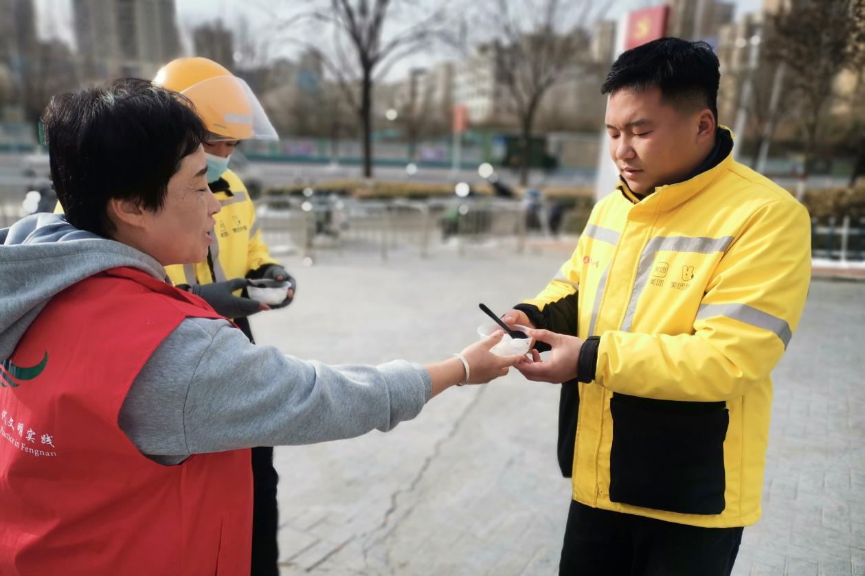 唐山市豐南區青年路街道錦繡觀邸社區志願者為外賣小哥送上熱騰騰的元宵。閆衛攝