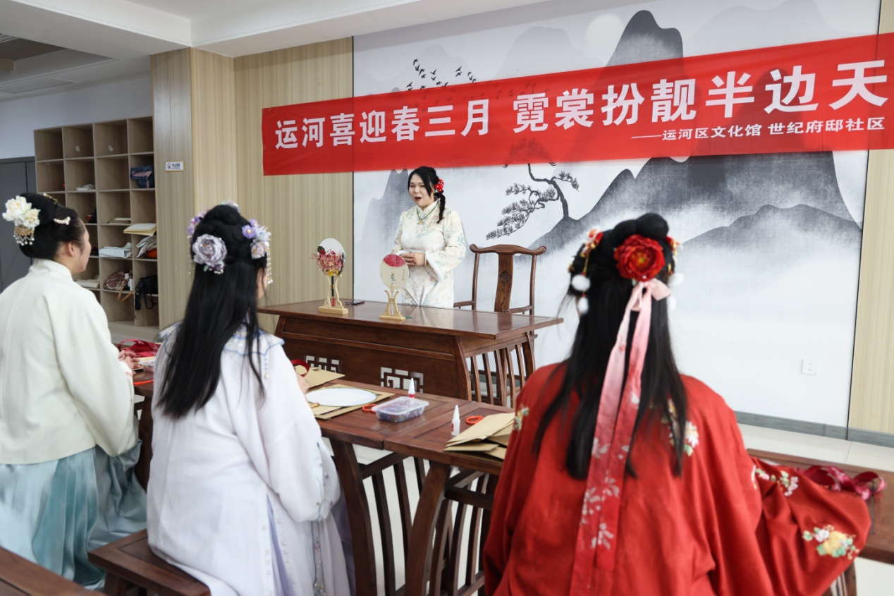 參與者身著色彩斑斕的傳統漢服，學習制作團扇。楊洋攝