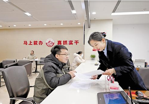 2月18日，河北省政務服務大廳企業服務中心，工作人員（右）在為群眾辦理業務。河北日報記者張昊攝