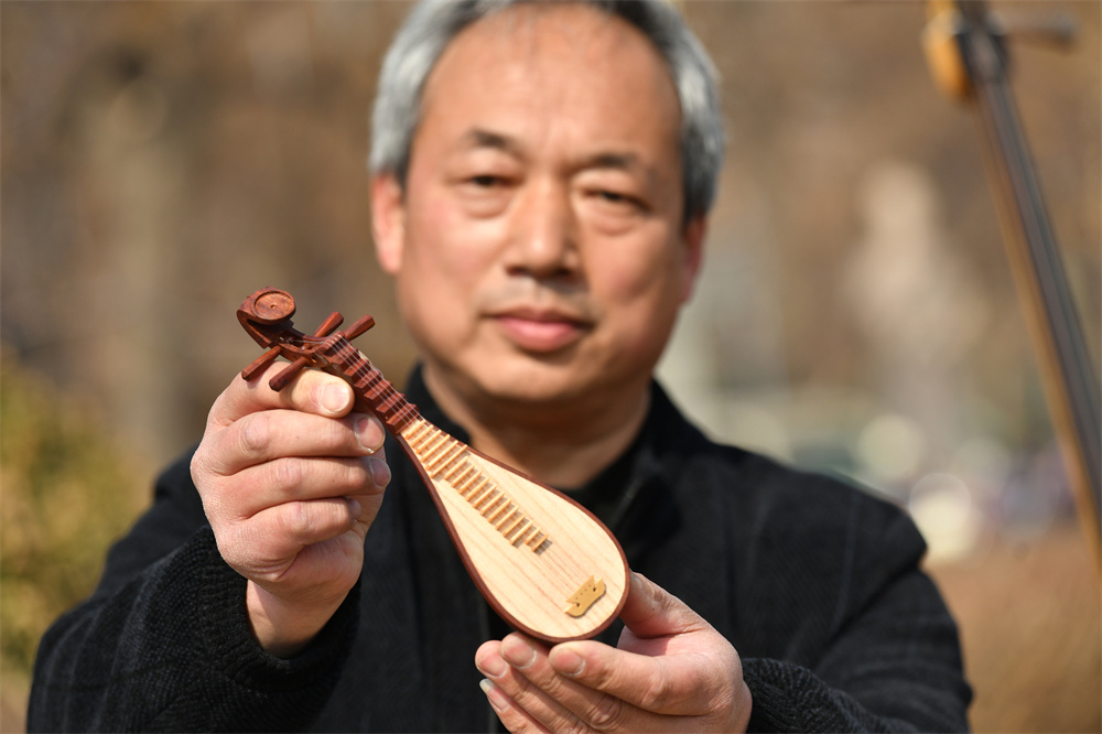 “非遺”老師傅在展示“非遺”技藝“三弦制作工藝”的模型。苑立偉攝