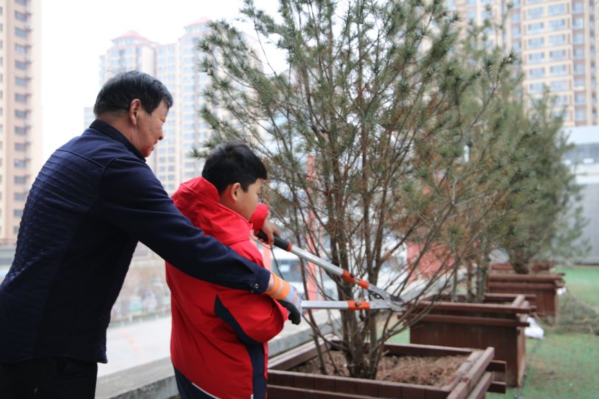3月12日，老师指导学生为小树剪枝。贾习芹摄