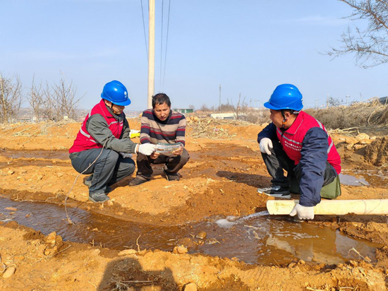 国网赞皇县供电公司工作人员田间地头宣传用电安全，检查灌溉设备。王一兰摄