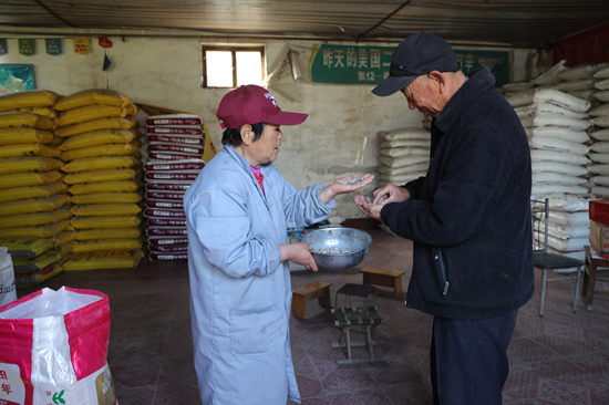 河北省顺平县城关中心供销合作社工作人员向前来采购的农户讲解肥料。张甜甜摄