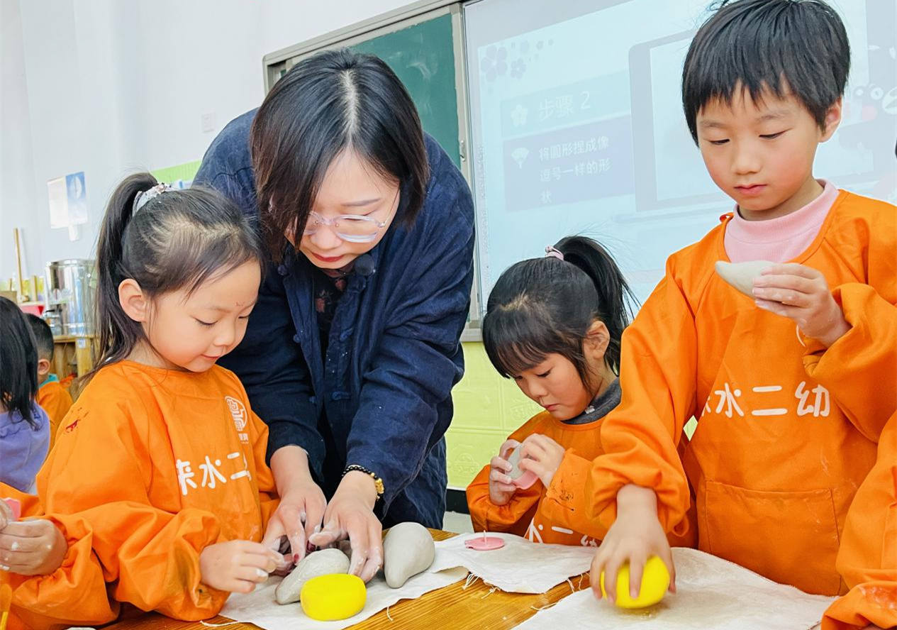 陶艺师指导孩子们制作陶艺。李金璐摄
