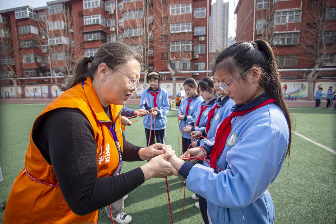 邯郸市红十字中安防减灾服务中心志愿者教孩子们绳结大比拼。聂长青摄