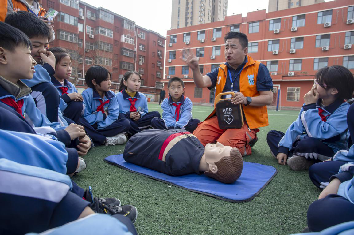 邯郸市红十字中安防减灾服务中心志愿者教孩子们AED除颤仪的使用方法。聂长青摄