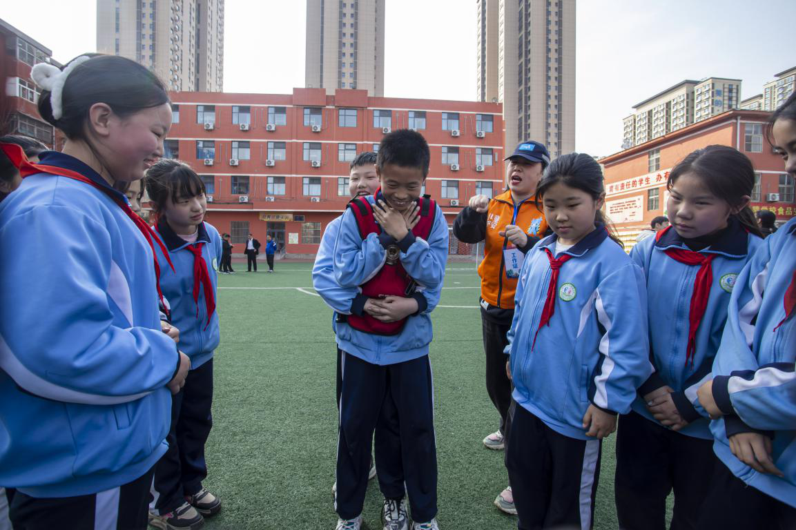 图邯郸市红十字中安防减灾服务中心志愿者教孩子们掌握海姆立克急救法。聂长青摄
