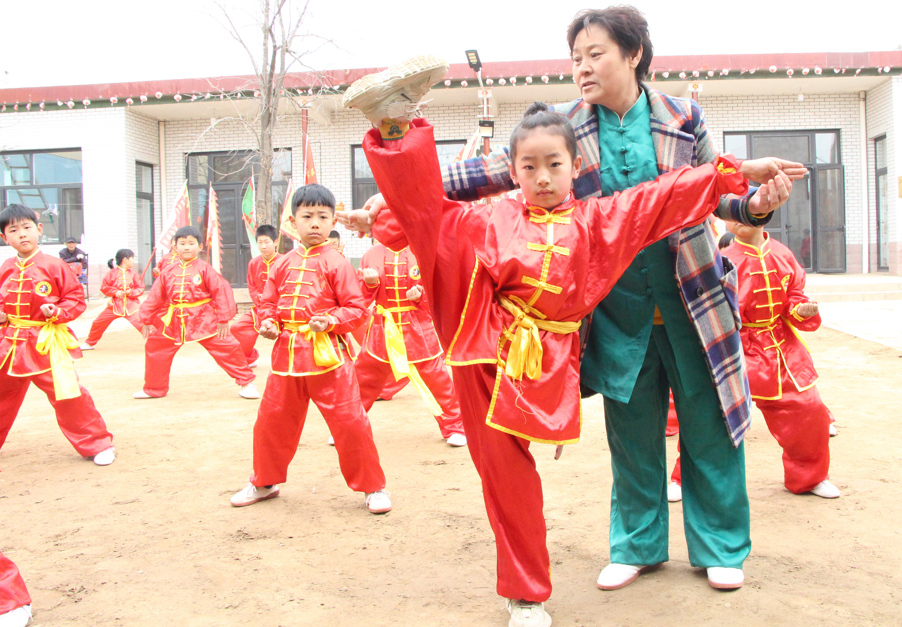 3月24日，在高陽縣邊家務村青少年少林武術培訓基地內，武術愛好者鄒杰英指導孩子練習基本功。楊瀰攝