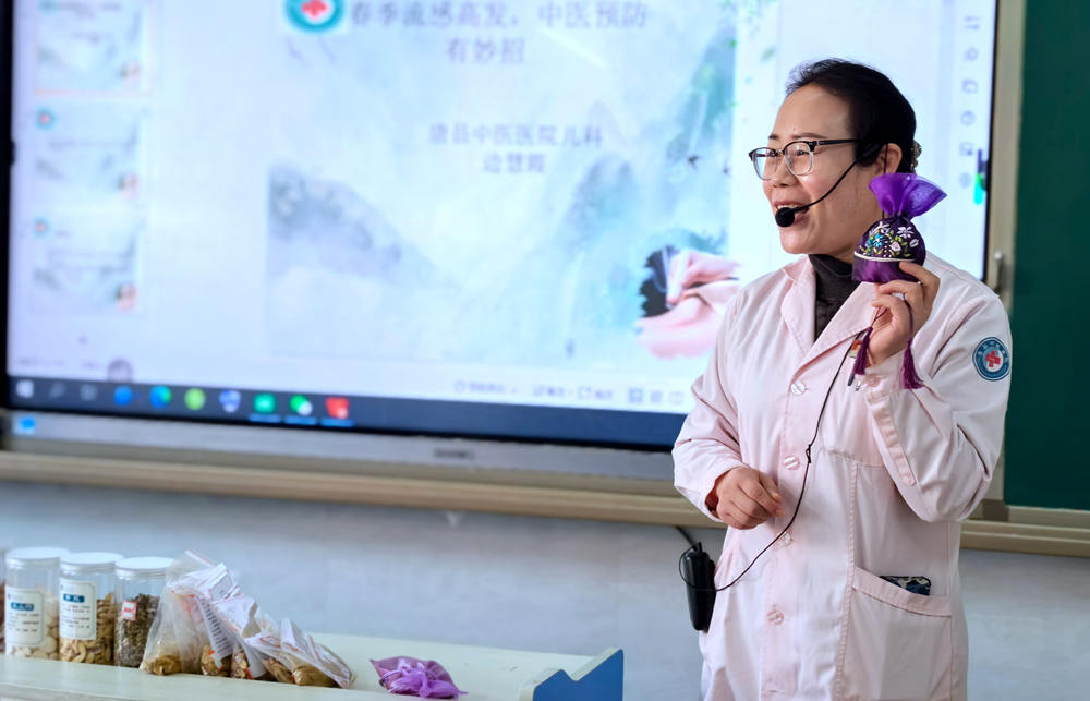 医生边慧霞向同学们讲解中药香囊的制作过程。陈亚娟摄